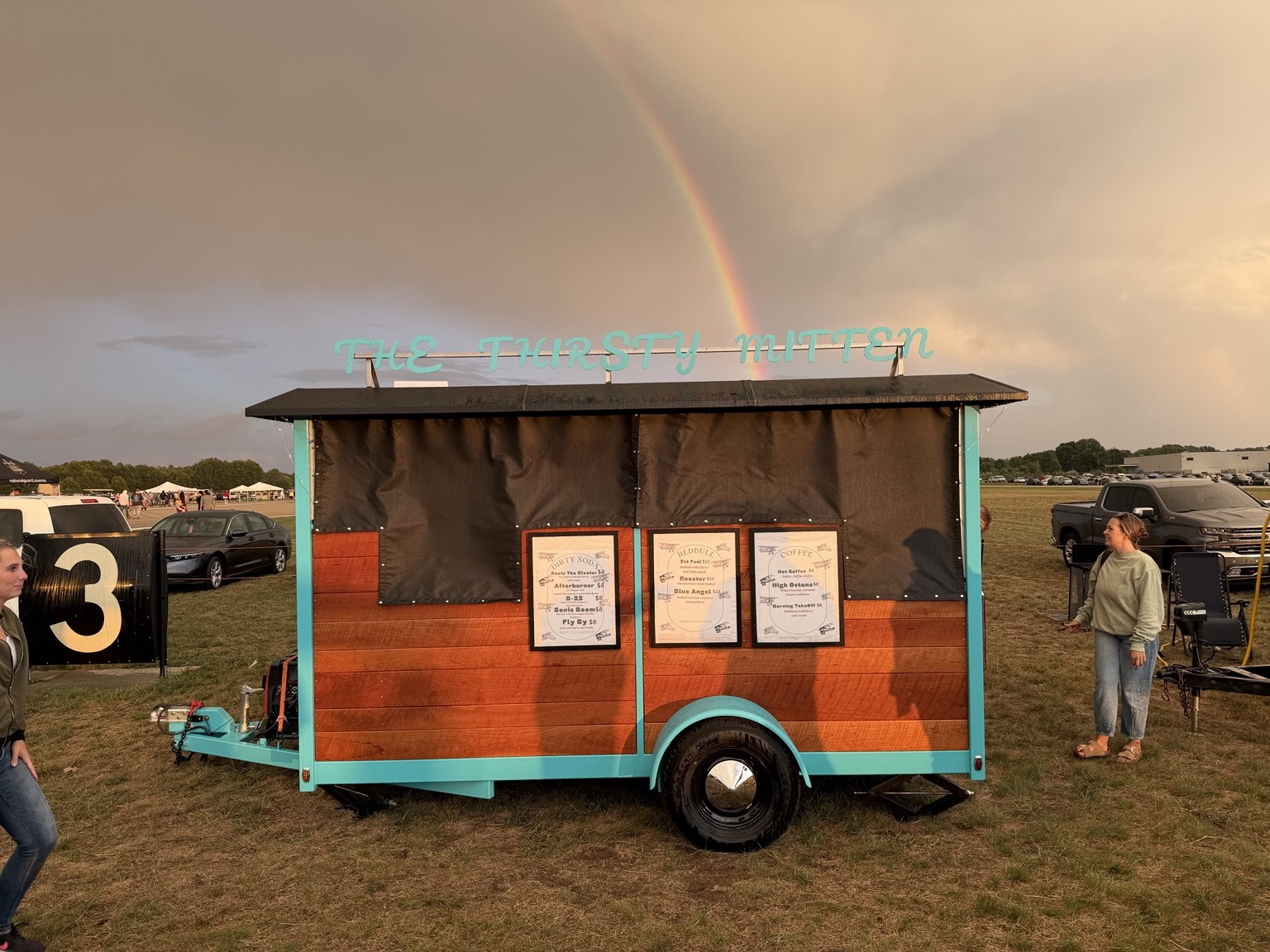 The Thirsty Mitten outdoor drink trailer beneath a rainbow at an event